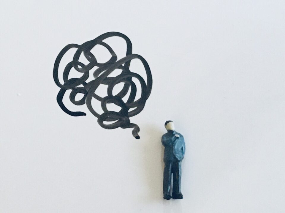 デスク周りの配線が気になる在宅ワークの男性