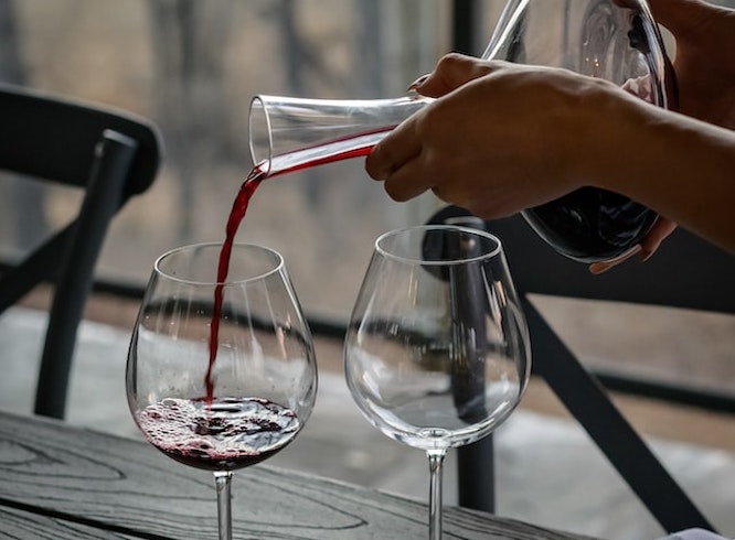 デキャンタージュしたワインを注ぐ人の手